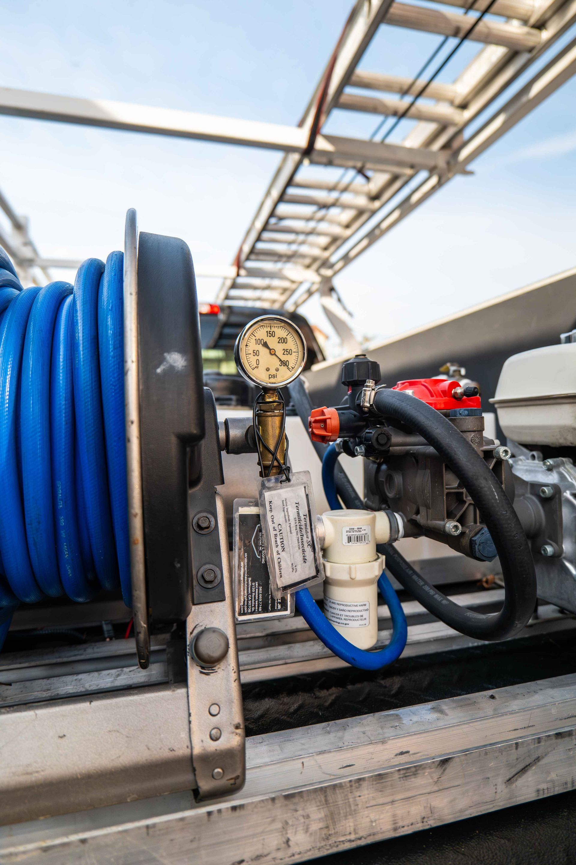 A man in a protective suit is spraying a house with a hose.