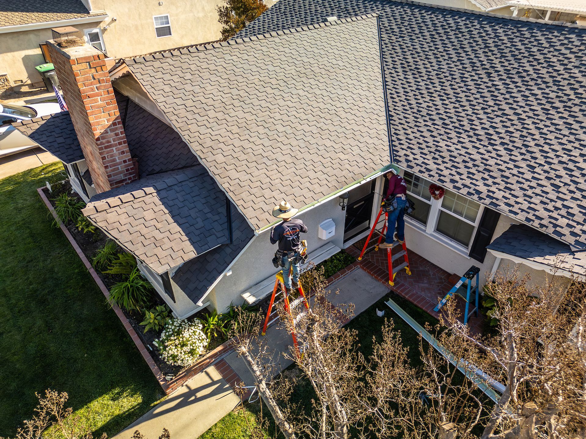 A group of men are working on the roof of a house.