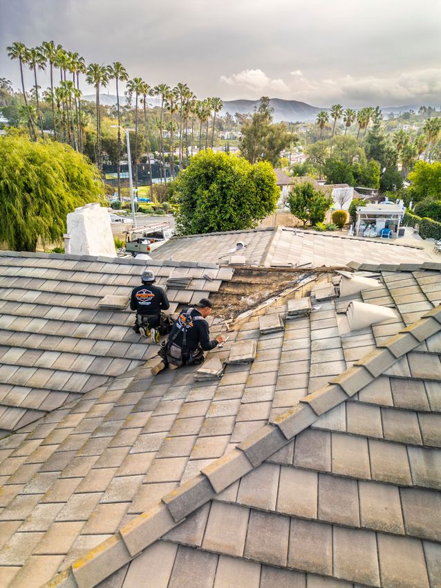 A group of men are working on the roof of a house