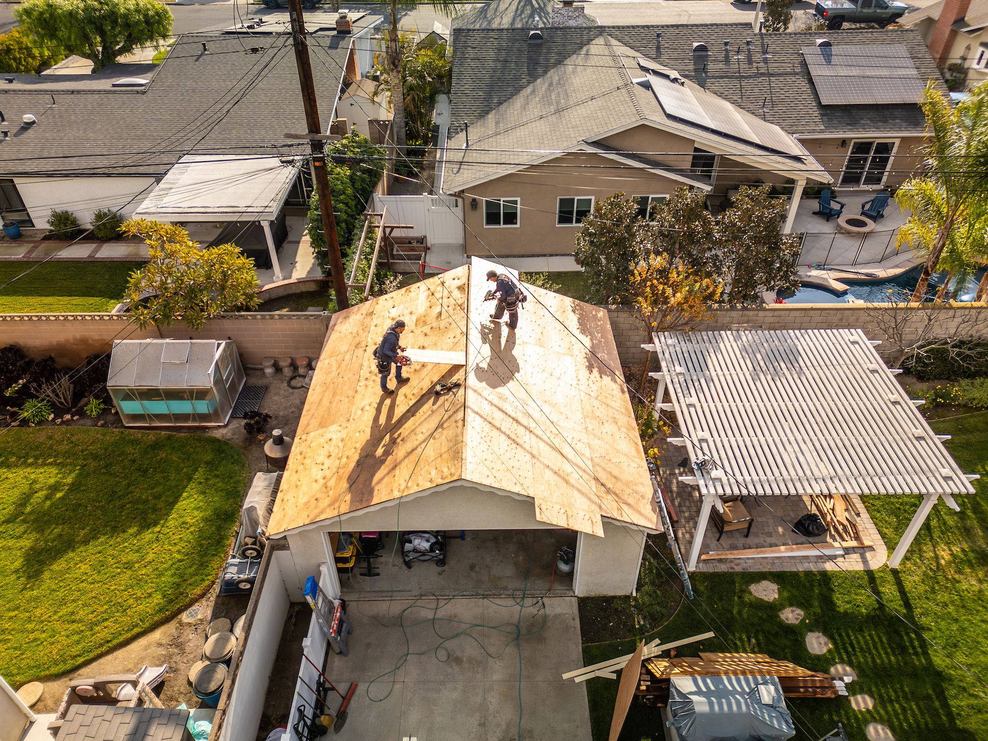 A group of people are working on the roof of a garage.