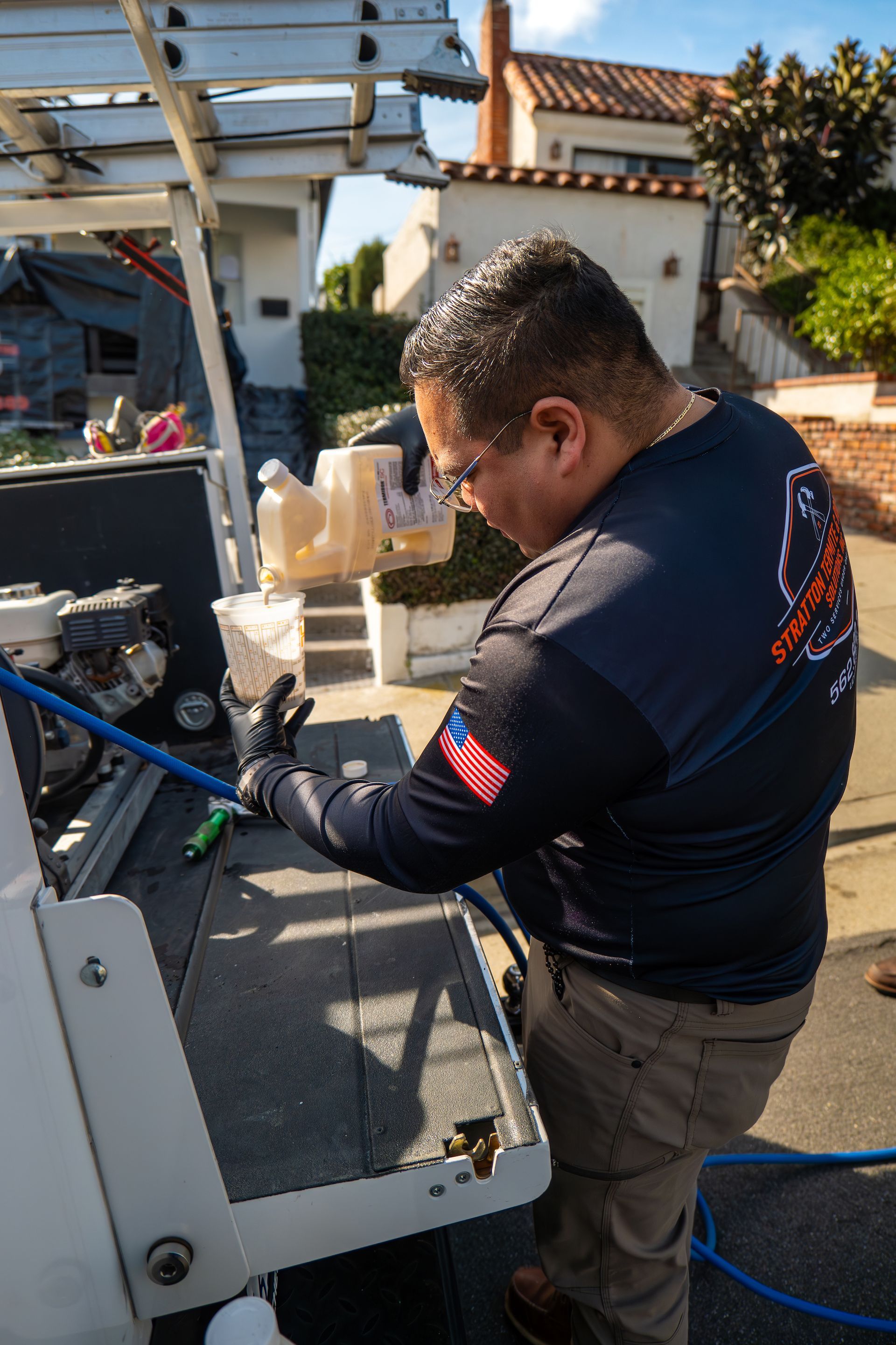 A man is working on a machine with a hose.