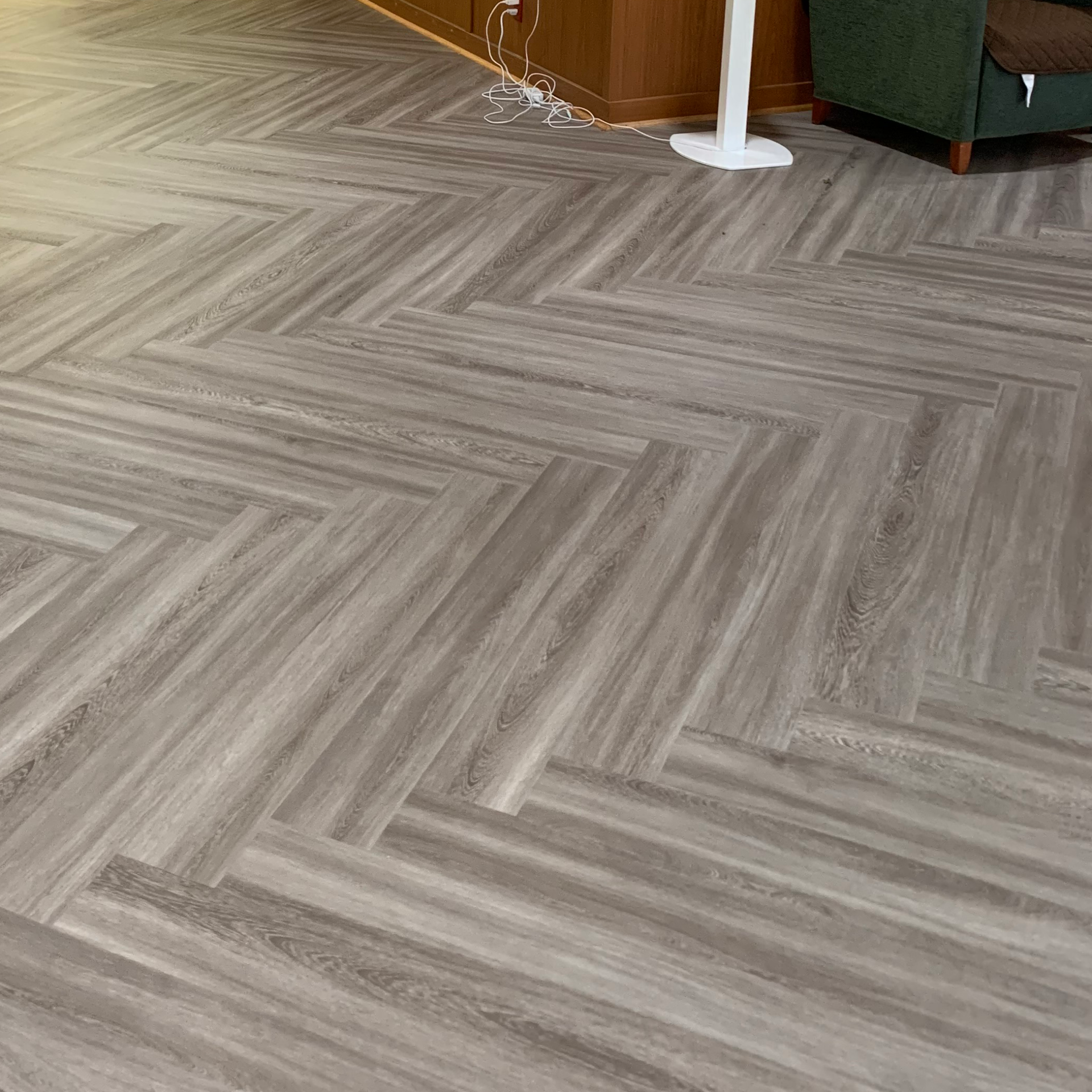 A living room with a herringbone pattern on the floor.