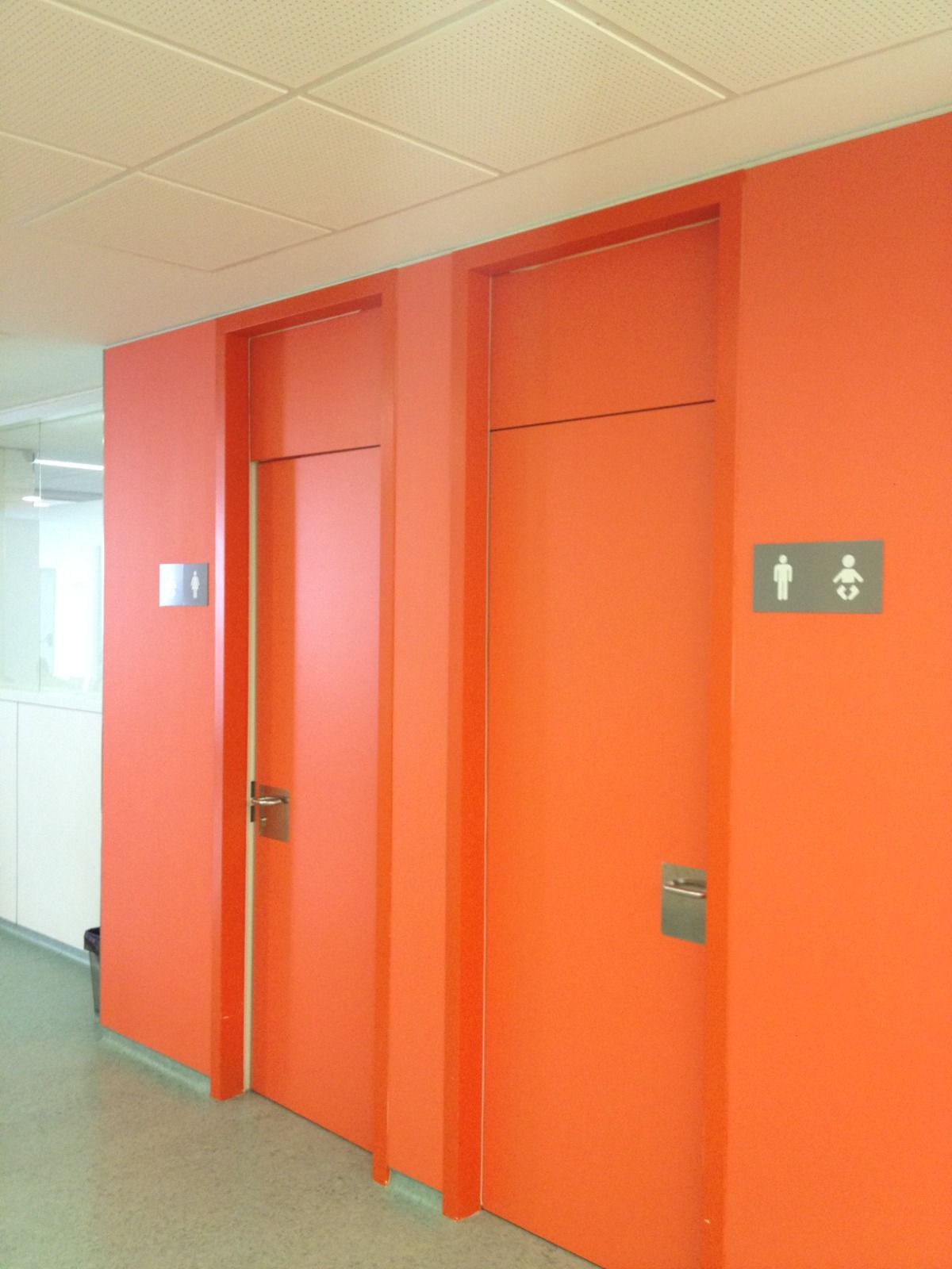 A hallway with orange doors and a sign that says toilet