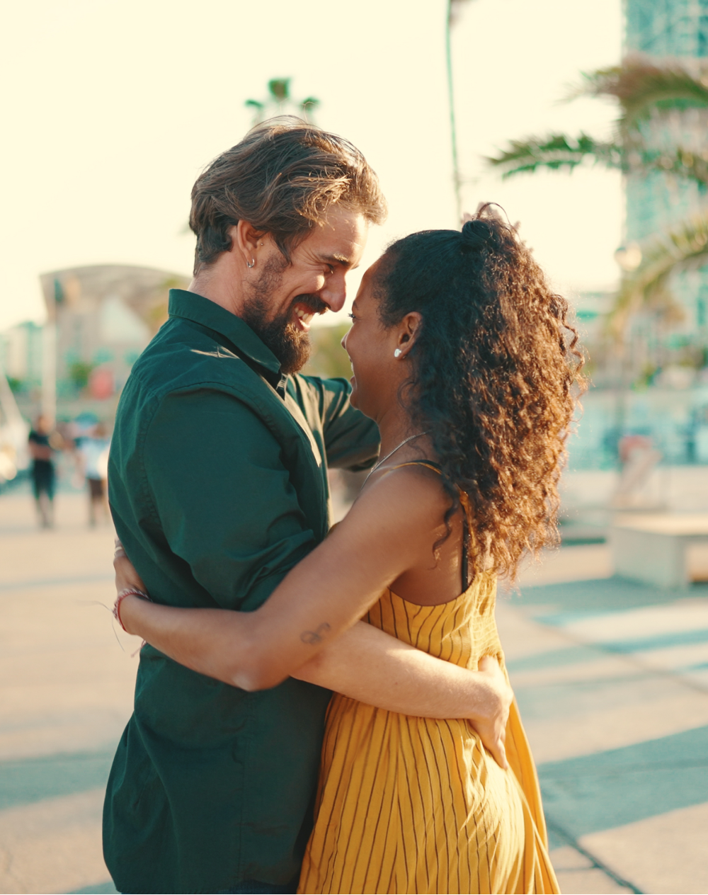 A man and a woman are hugging each other and looking at each other.