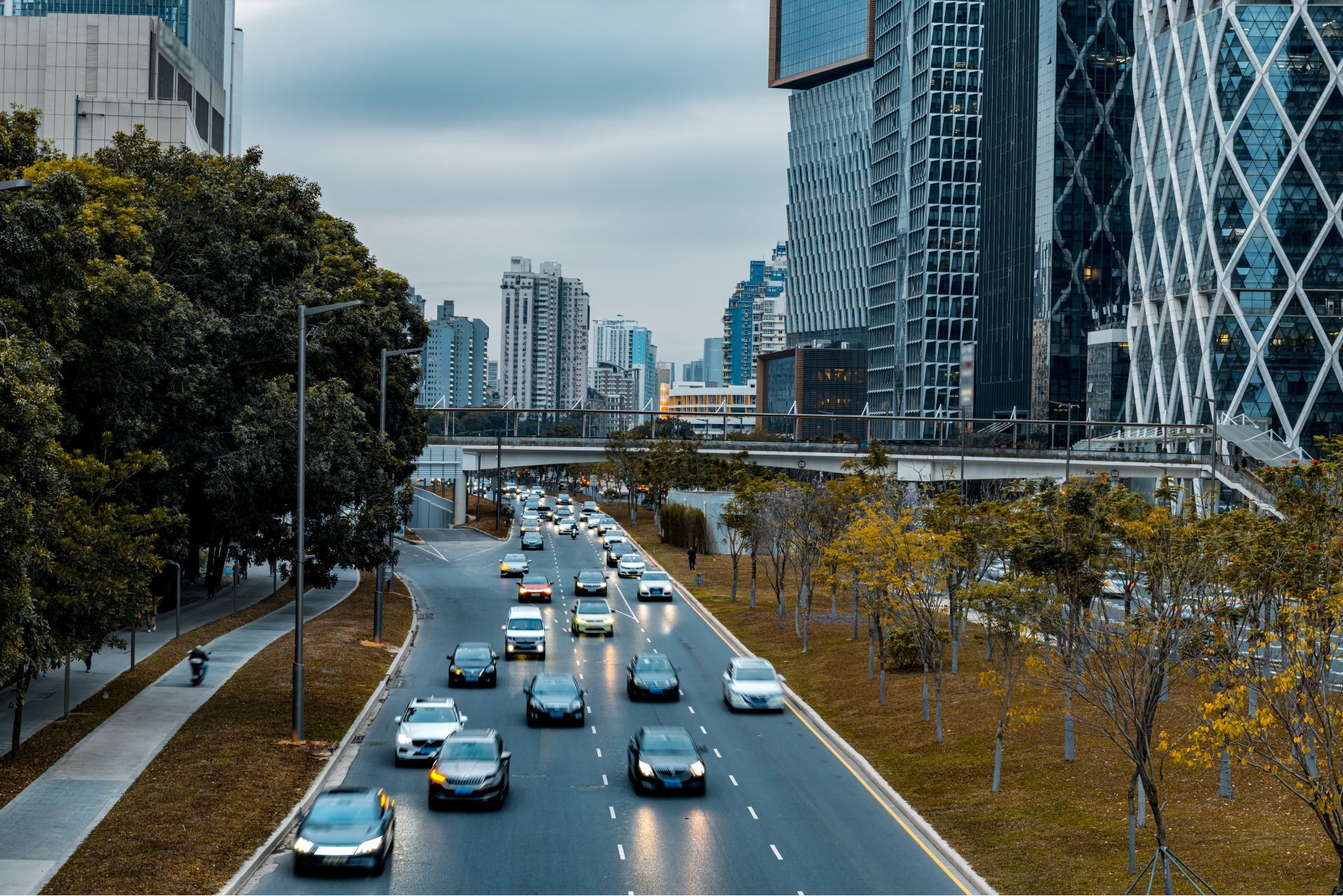 A lot of cars are driving down a highway in a city.