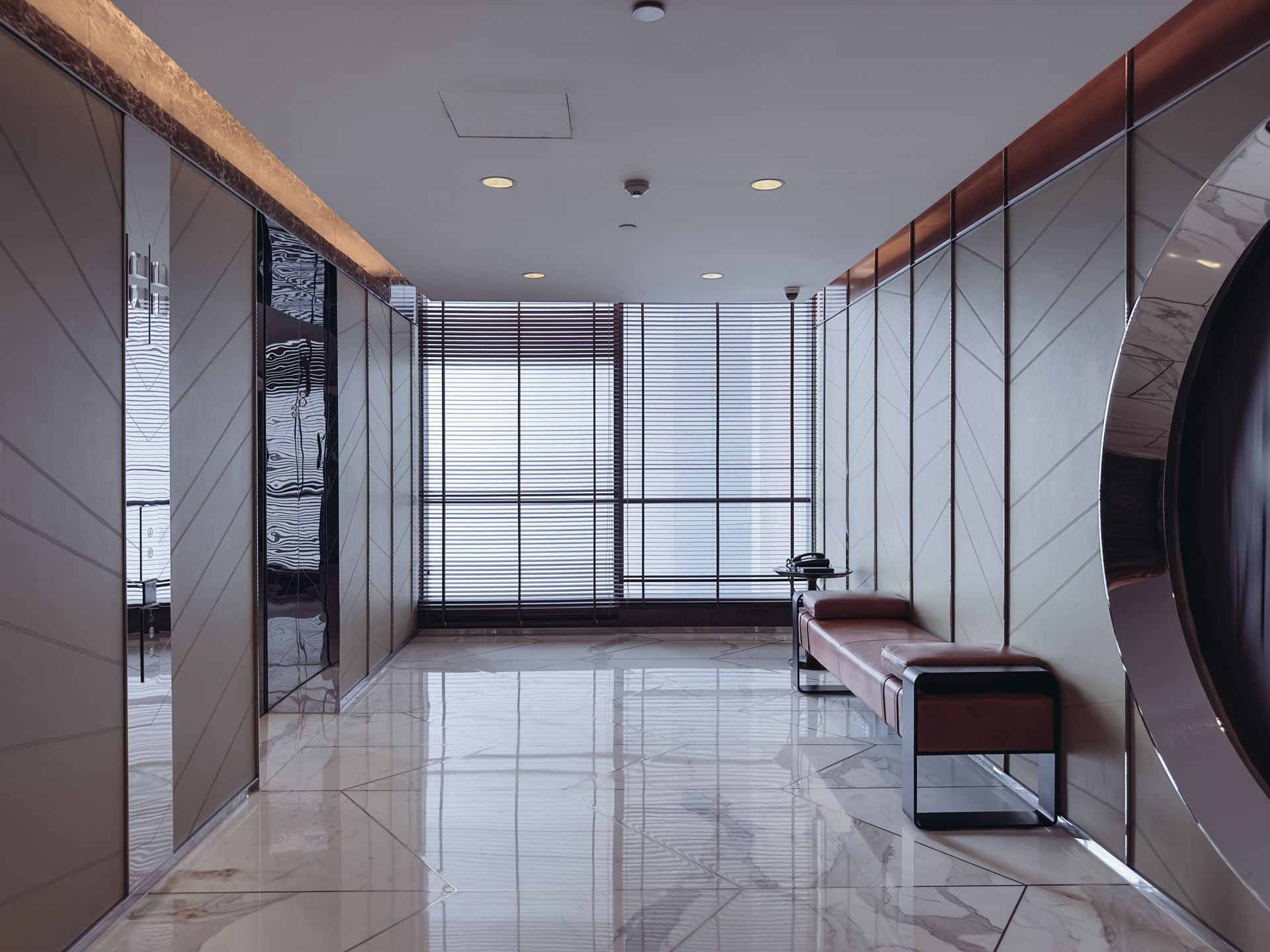 A long hallway with a bench in the middle of it