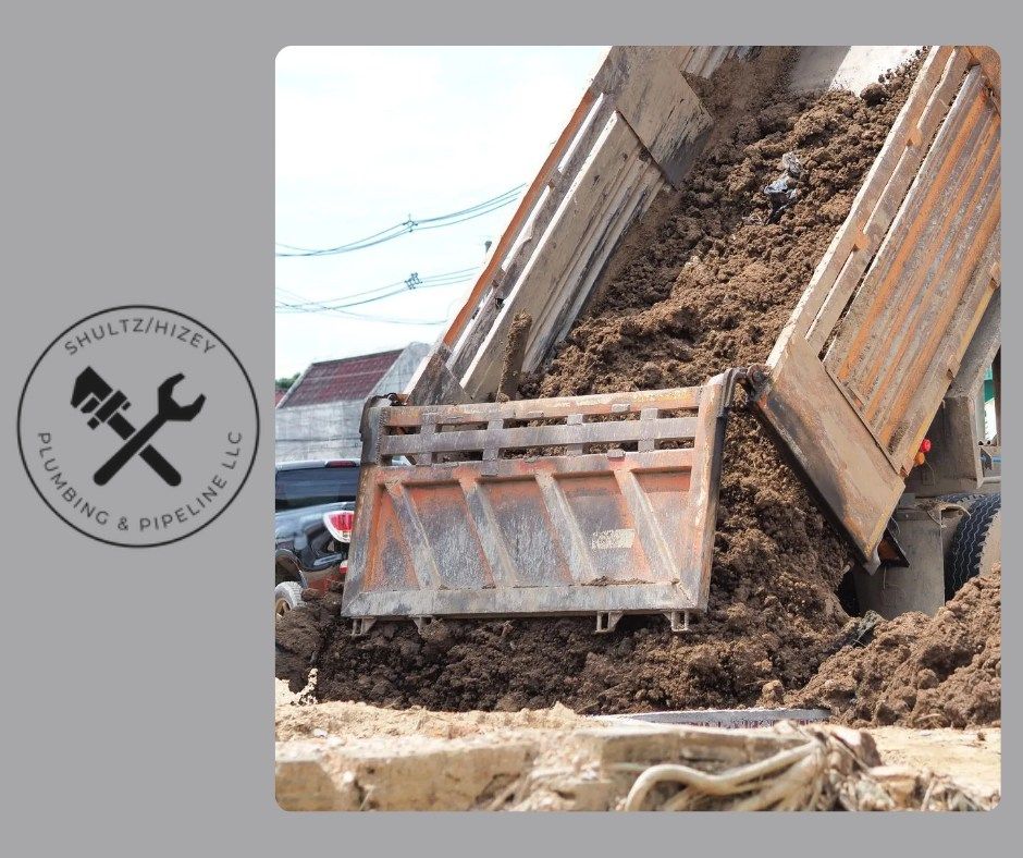 Dump truck unloading soil; Schultz/Hizet Plumbing & Pipeline LLC logo.