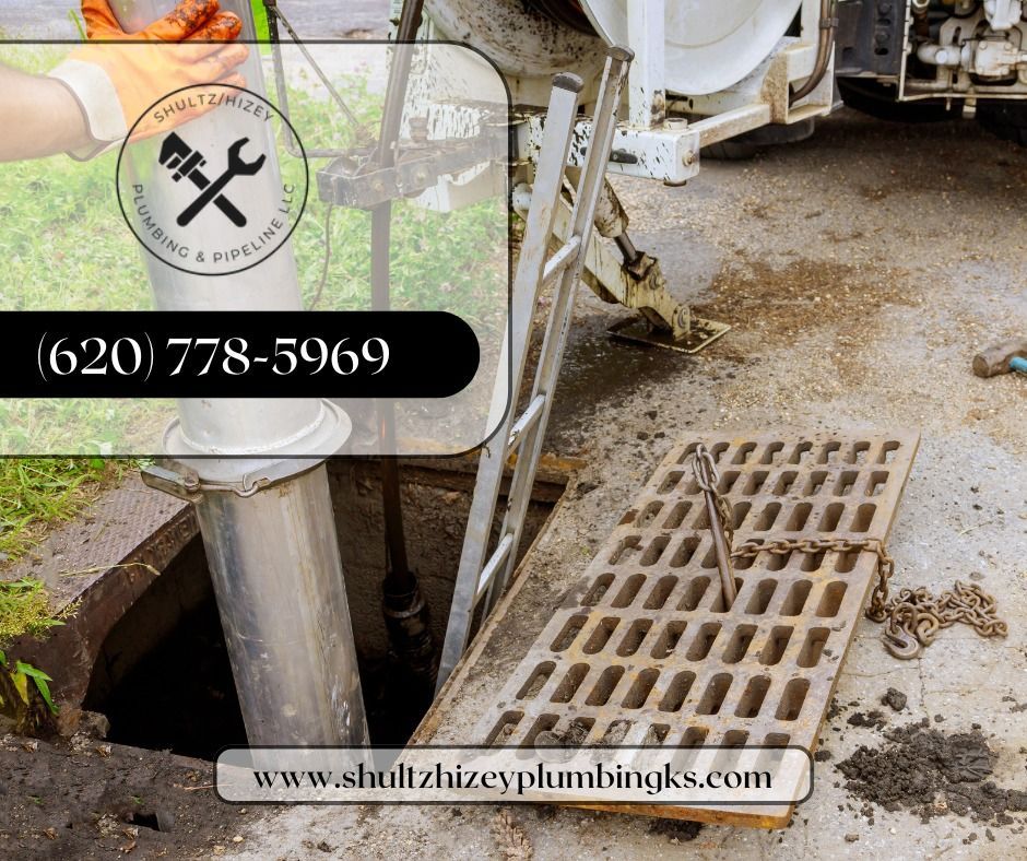 Plumbing services at a sewer. A manhole cover is open. A ladder leads down. The company’s logo