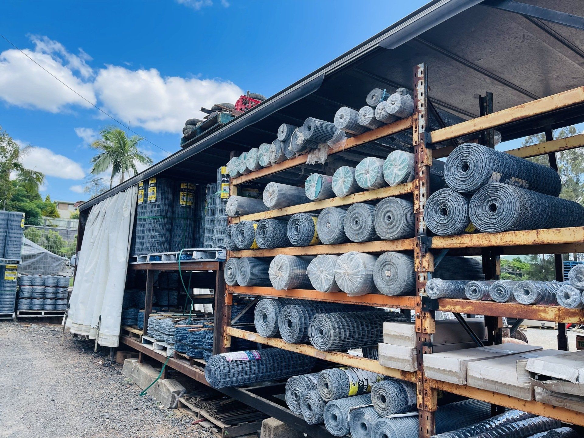 A warehouse filled with lots of rolls of wire fencing.