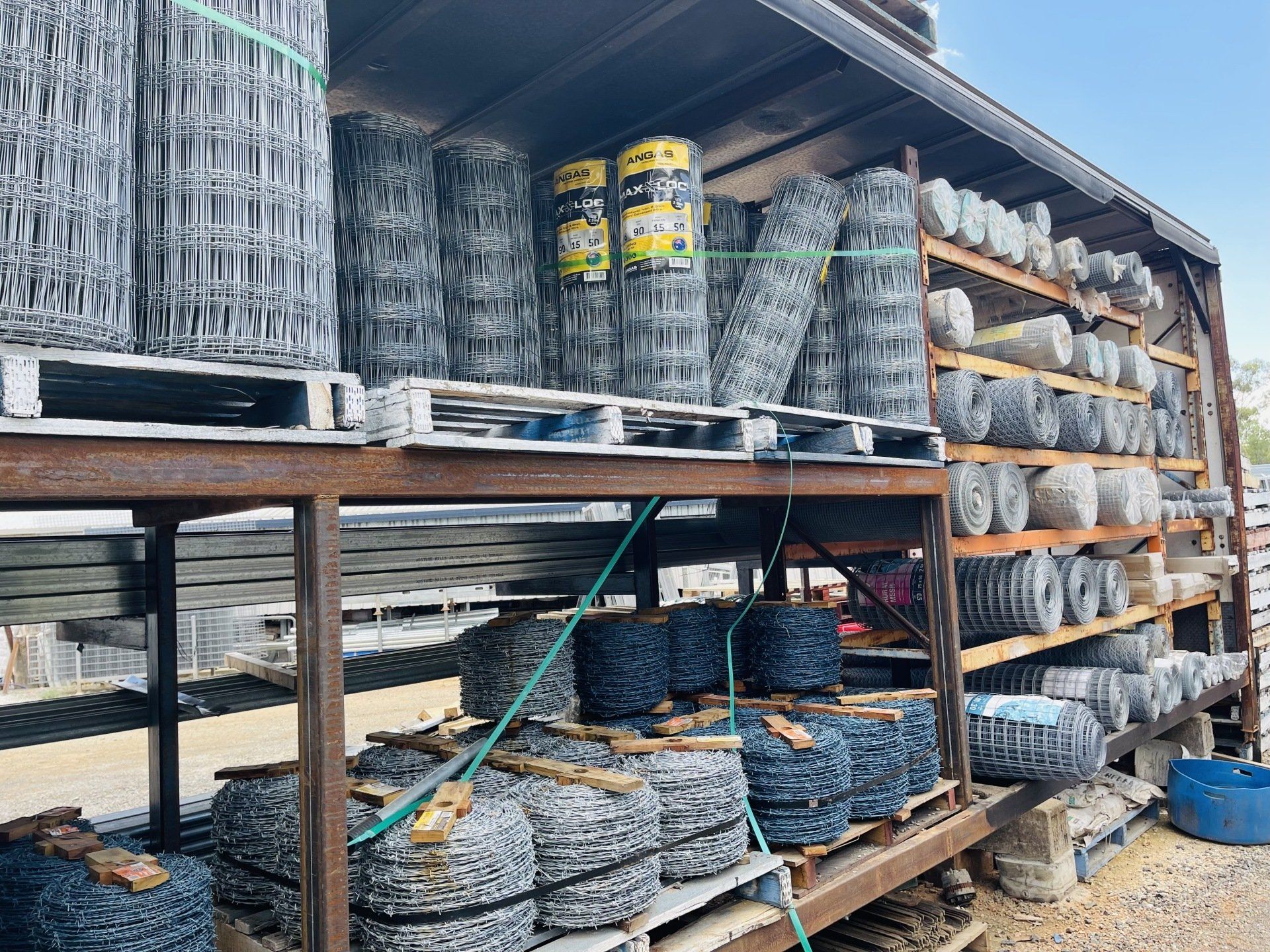 A warehouse filled with lots of wire fencing and pallets.