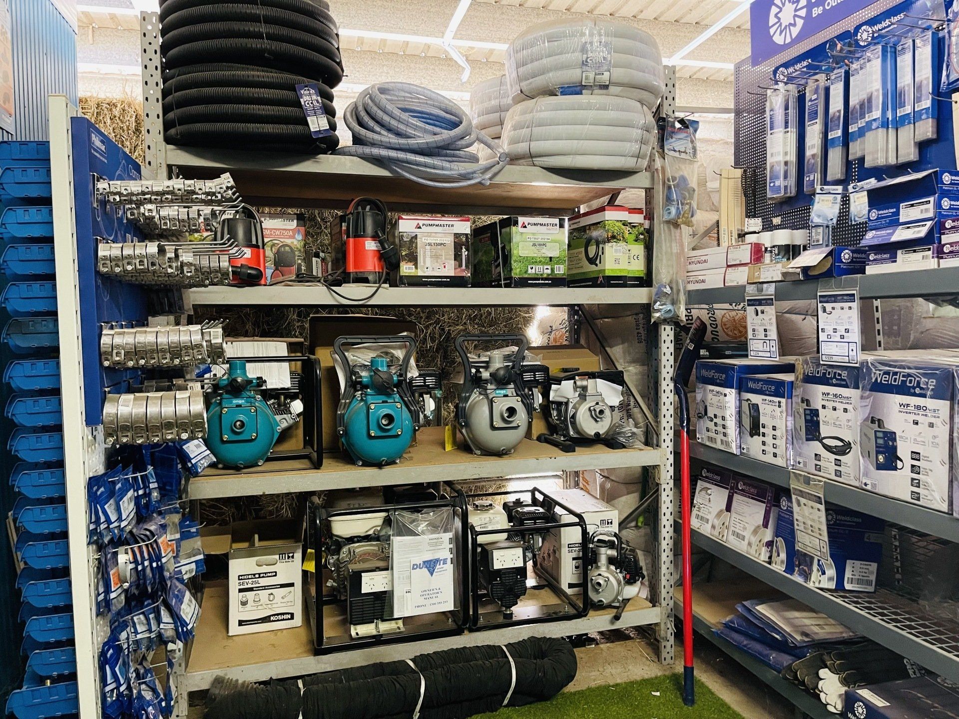 A shelf in a store filled with lots of water pumps and hose.