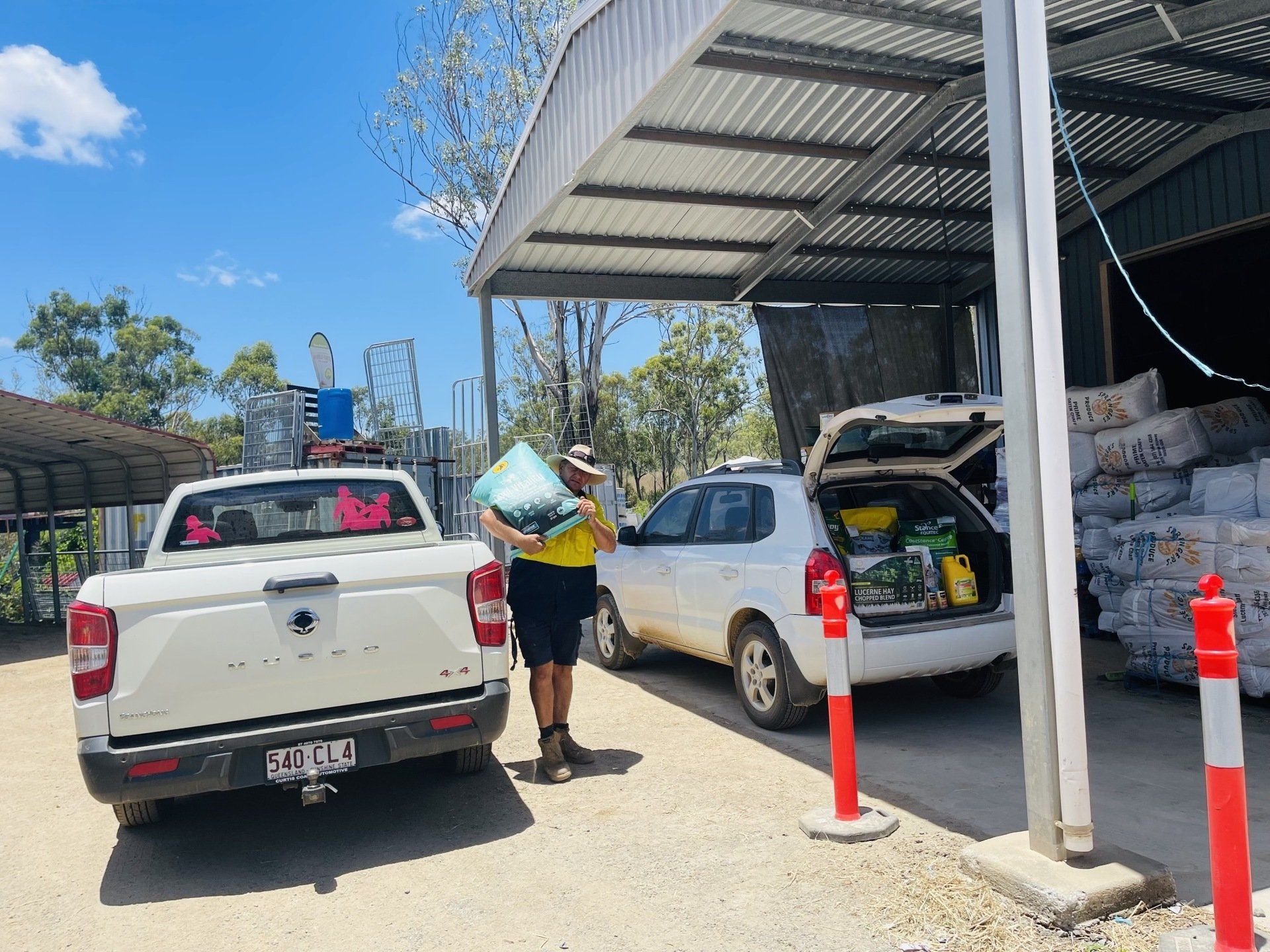 A man is carrying a bag in front of a white truck.