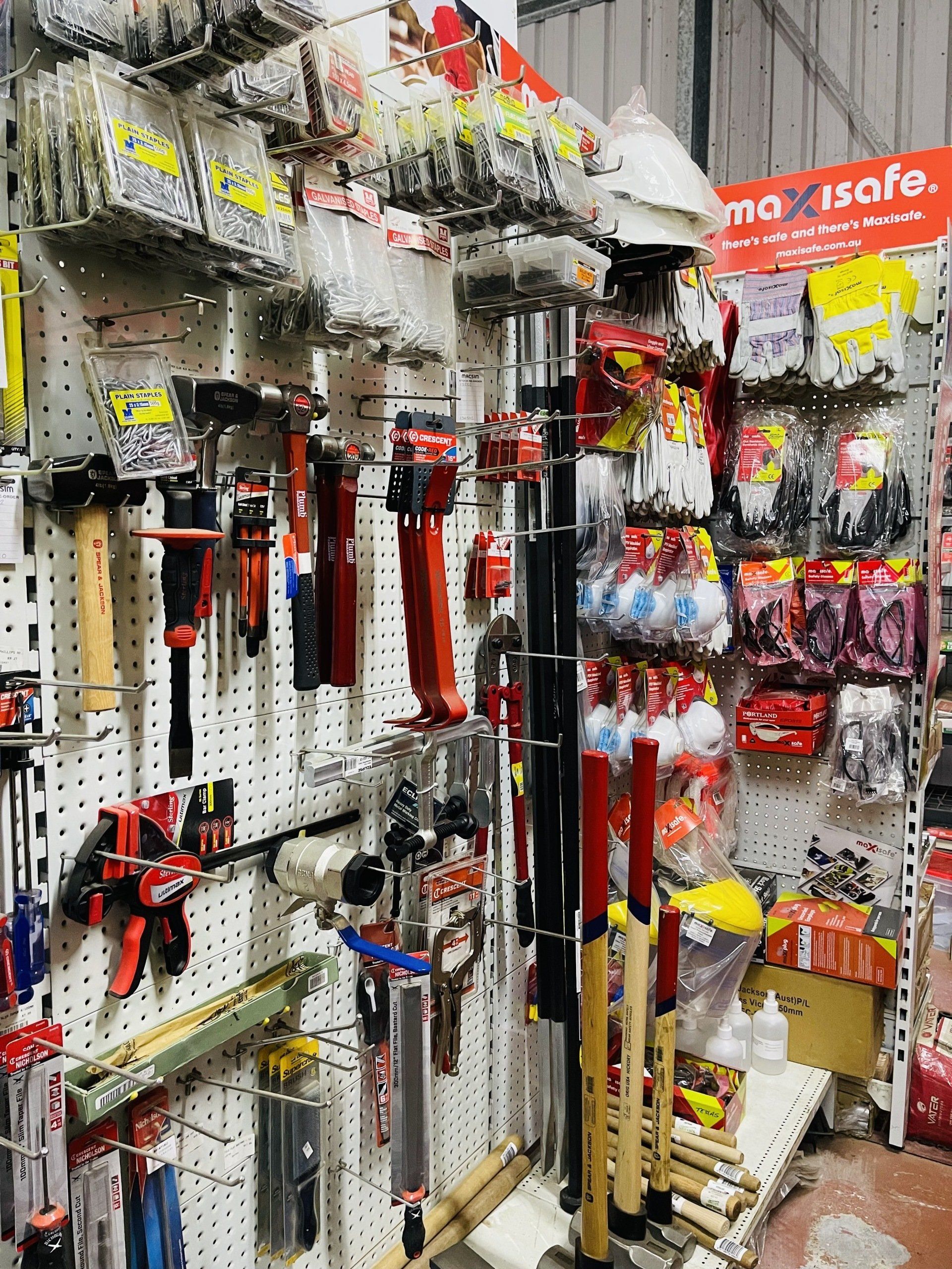 A bunch of tools are hanging on a wall in a store.