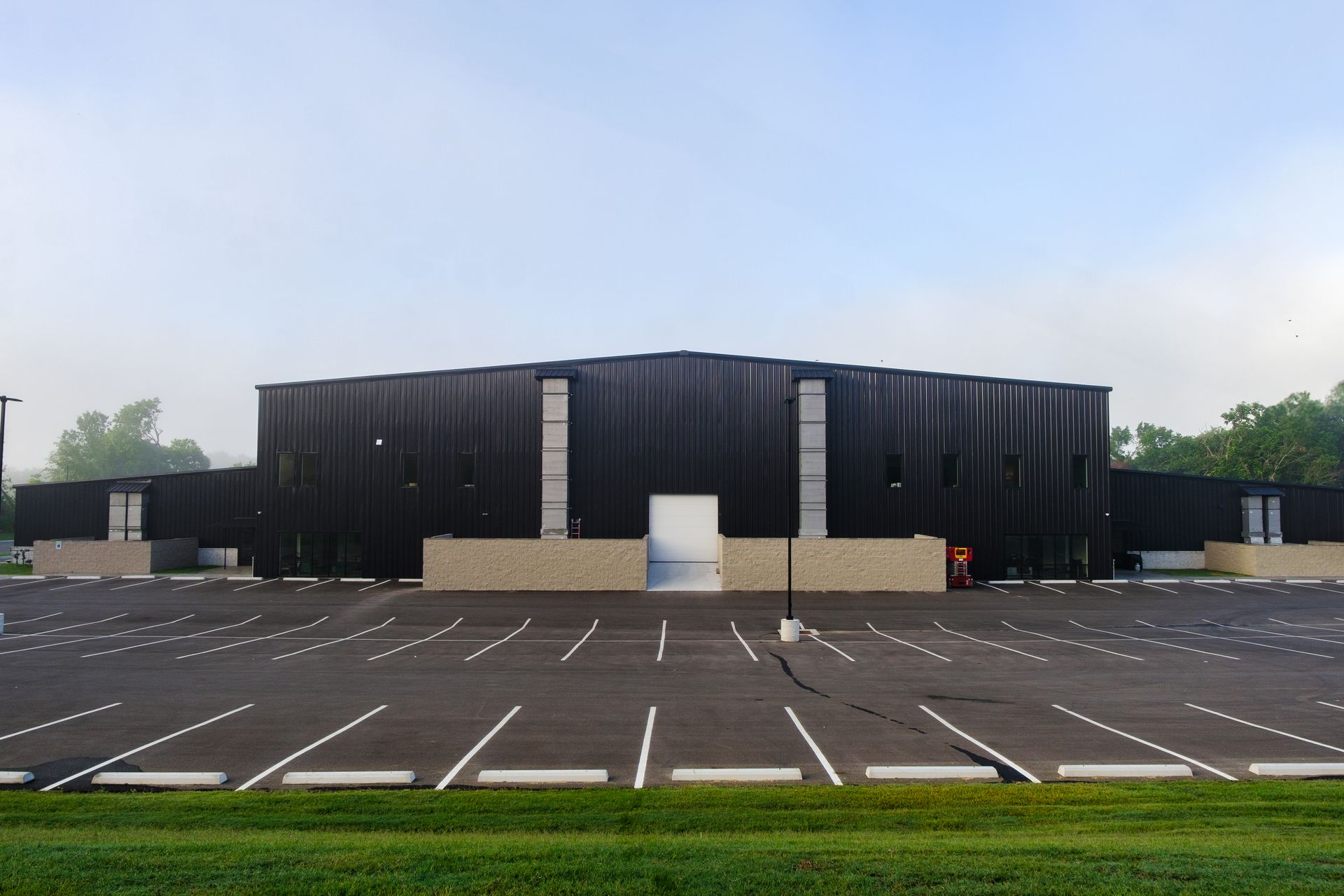 Large, dark building with a wide parking lot in front. The building has a symmetrical shape with a light-colored entrance.