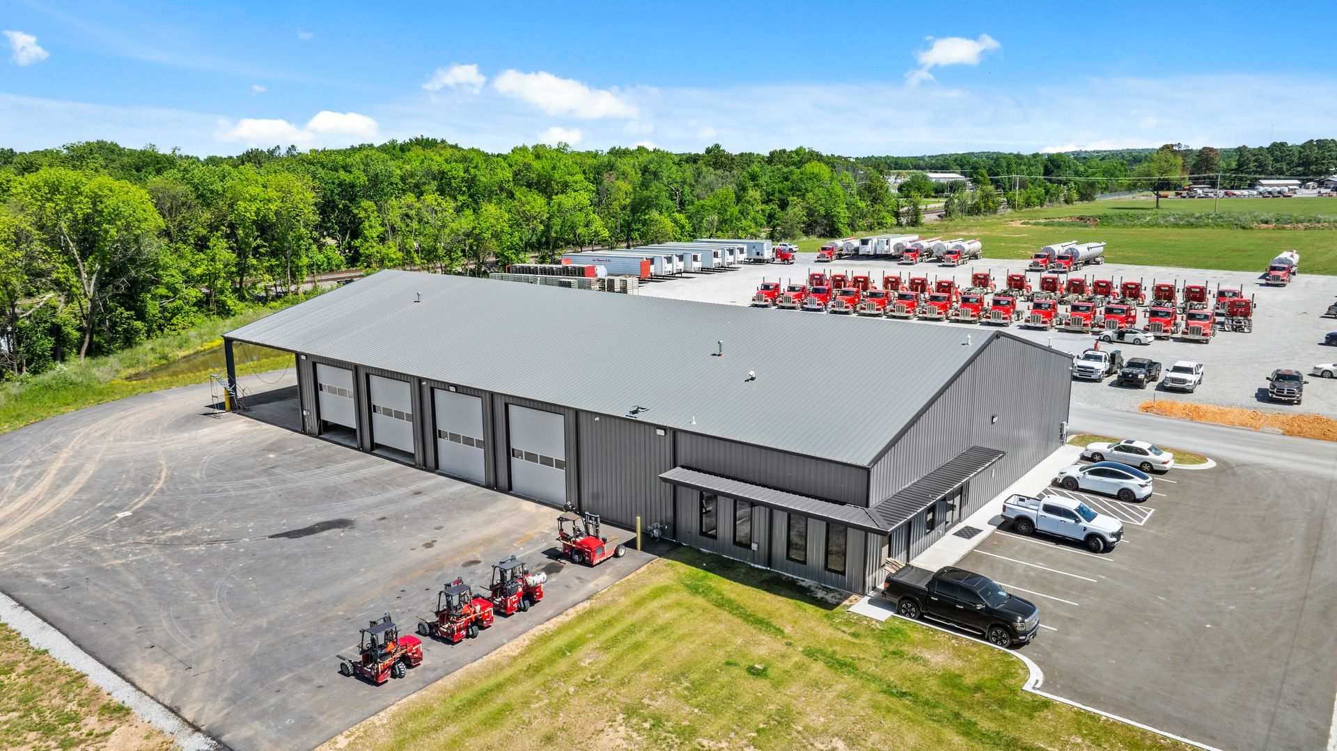 Drone view of a gray commercial metal building truck shop built and manufactured by Quality Metal Building Systems In Gentry, Arkansas