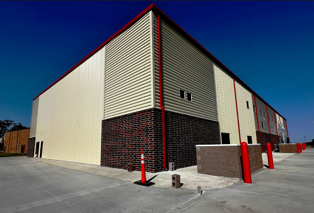 A large white and red building with a blue sky in the background.