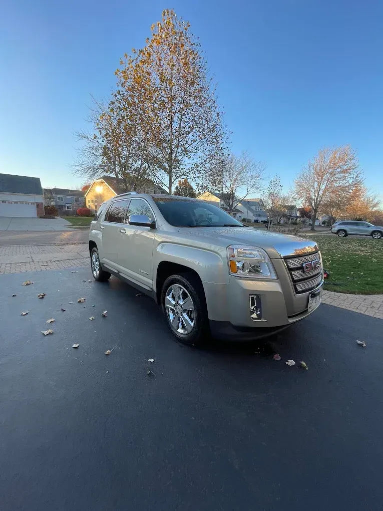 Silver SUV parked on a quiet street with autumn trees and a clear blue sky