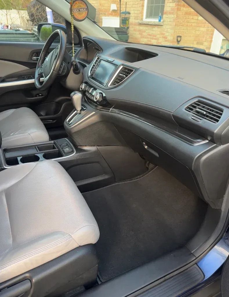 Car interior with gray seats and black dashboard, viewed from the passenger side