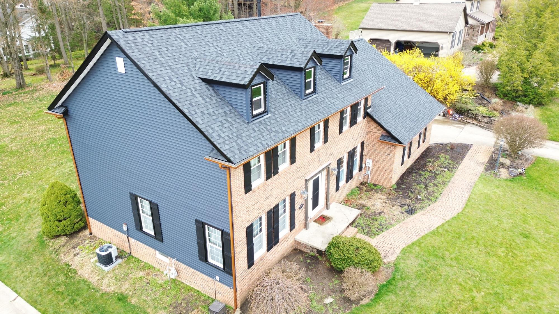 An aerial view of a large house with a new roof.