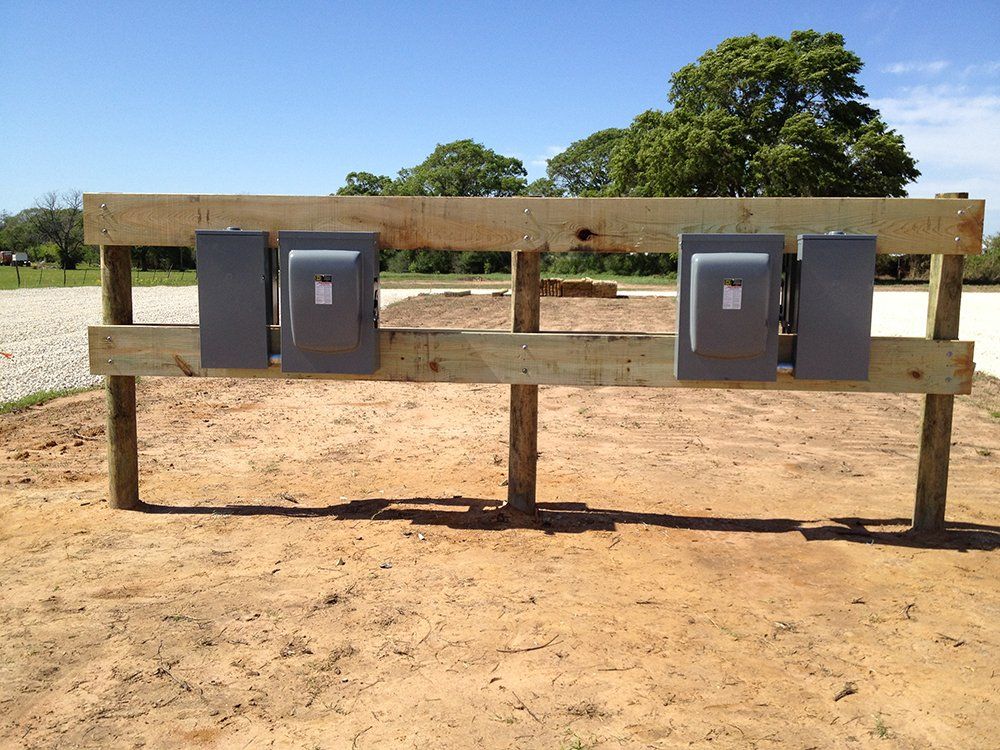 a wooden fence with electrical boxes attached to it