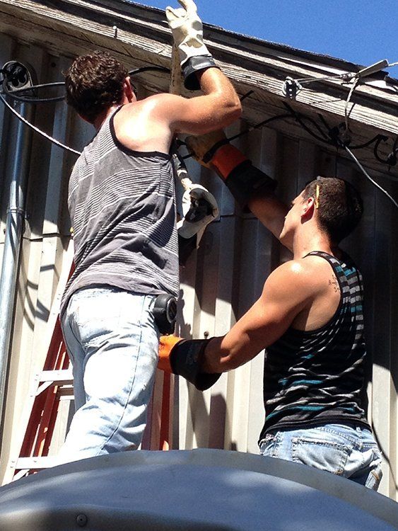 two men are working on the electricals of a building