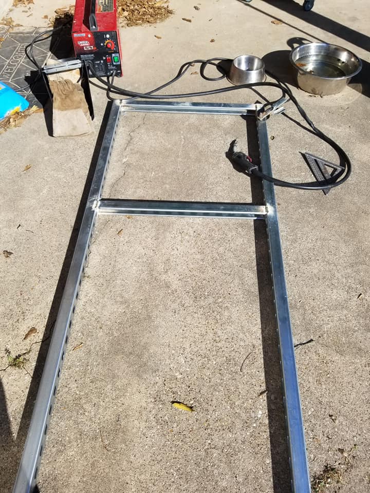 a metal ladder is sitting on the ground next to a welding machine