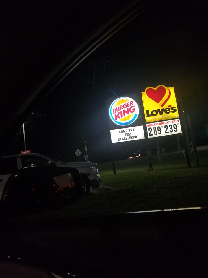 a burger king and love 's sign are lit up at night
