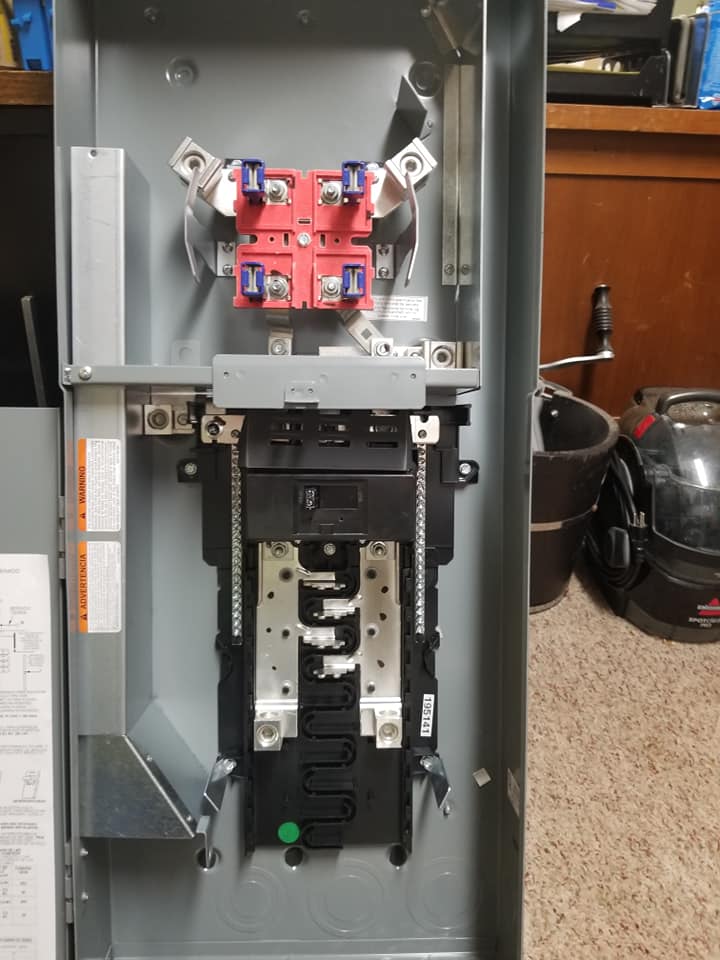 the inside of a electrical box with a vacuum cleaner in the background
