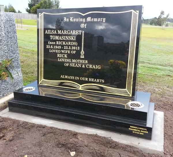 headstone with gold book decoration