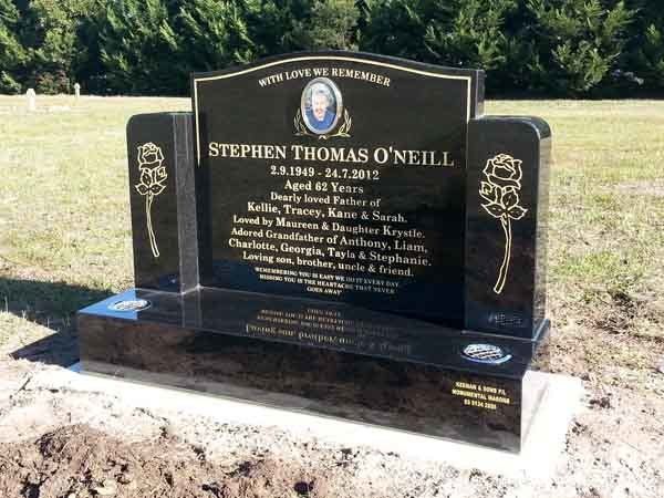 black headstone with gold flowers