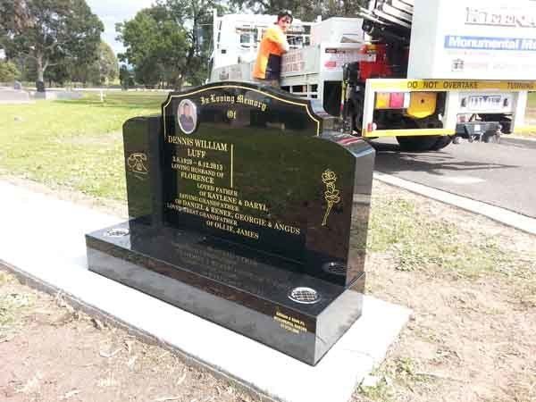 grey headstone with gold writing
