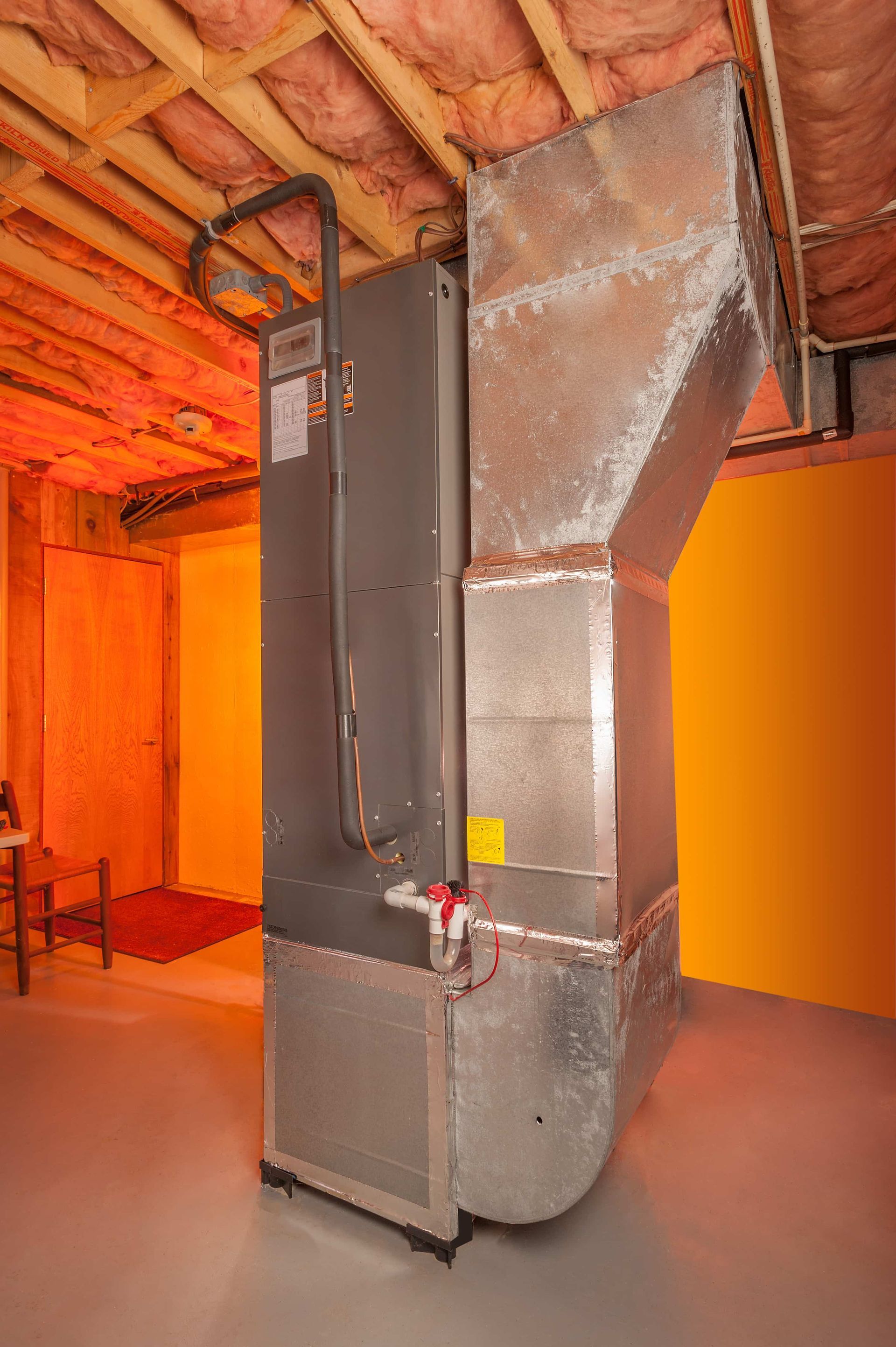 A large air conditioner is sitting in a basement.