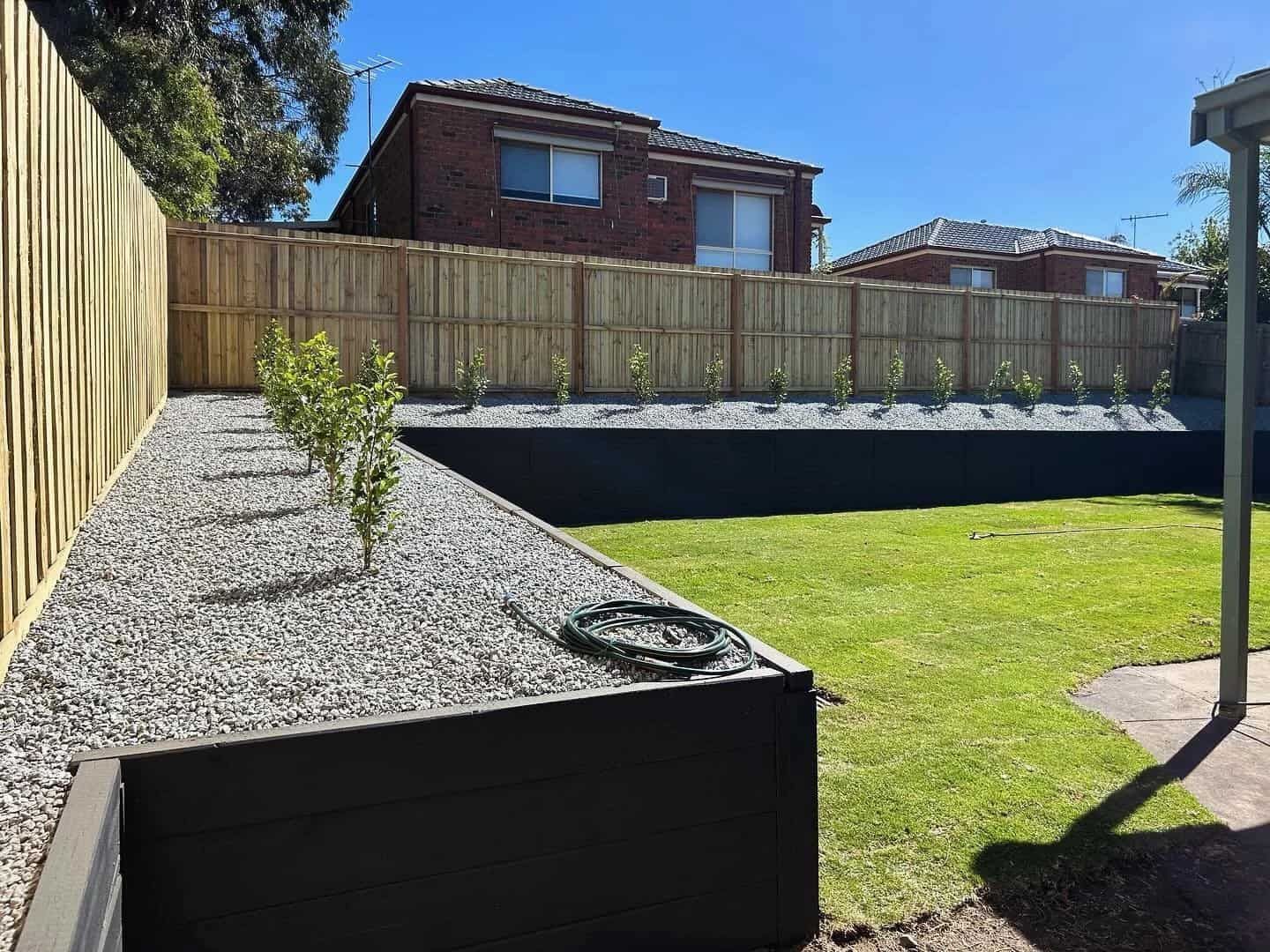 Backyard With a Raised Garden Bed Filled With Gravel and Young Plants — MGP Landscaping in Geelong, VIC 