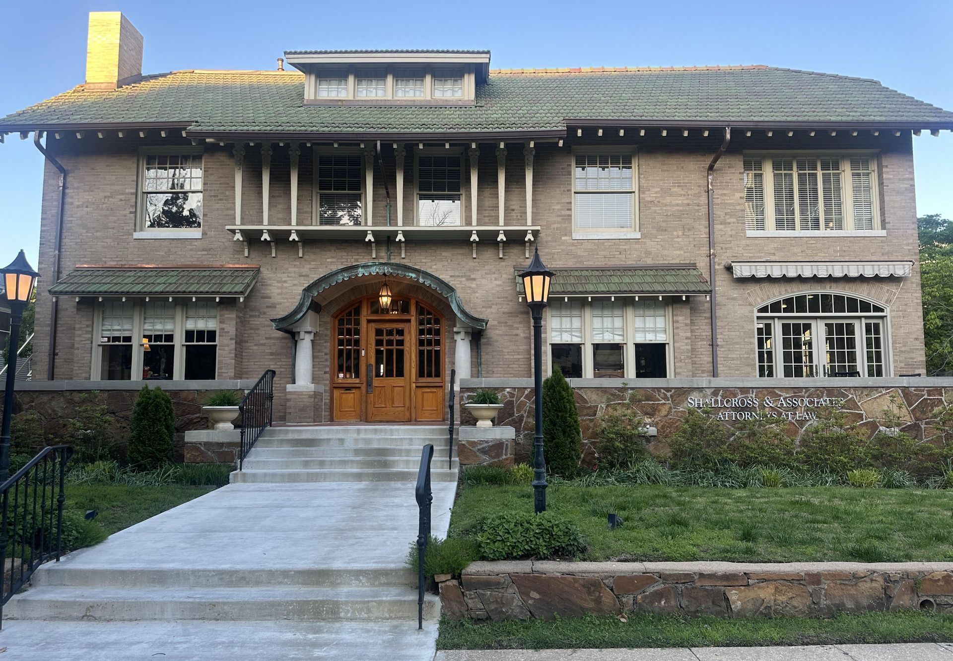 A large brick house with a green roof