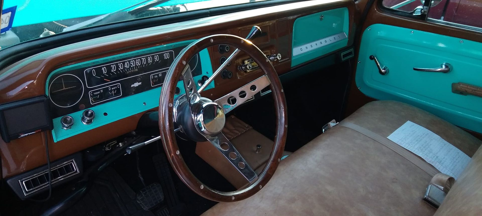 steering wheel and teal interior of a vintage truck 