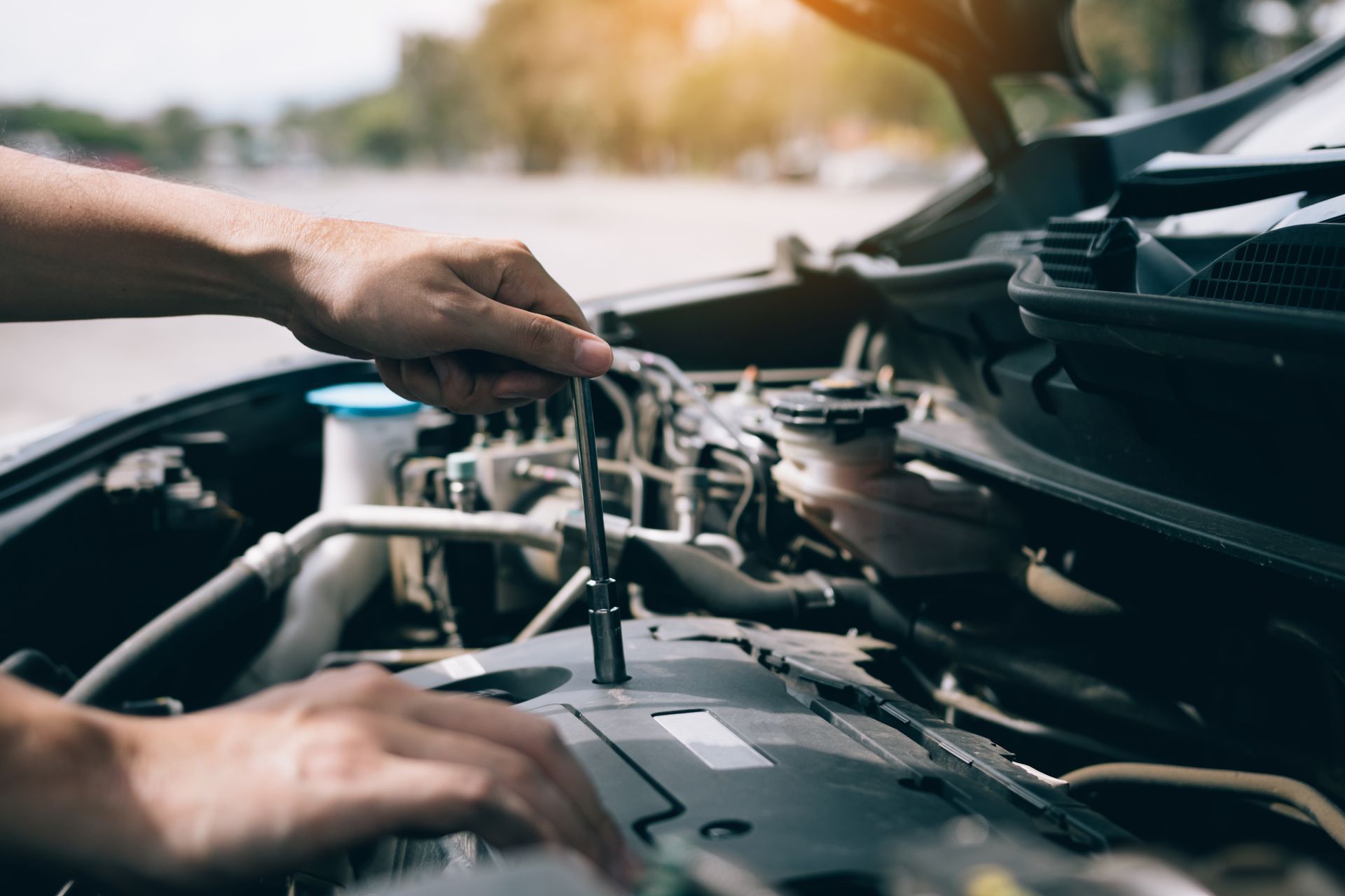 stock image of man working on a car engine 