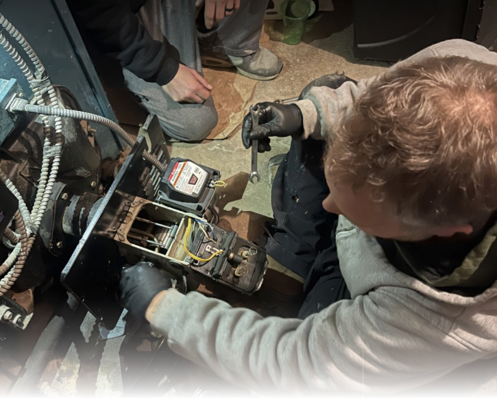 A gray air conditioner is sitting on a concrete platform outside of a house.
