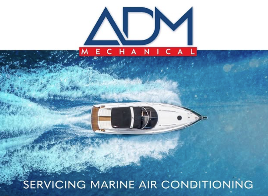 A gray air conditioner is sitting on a concrete platform outside of a house.