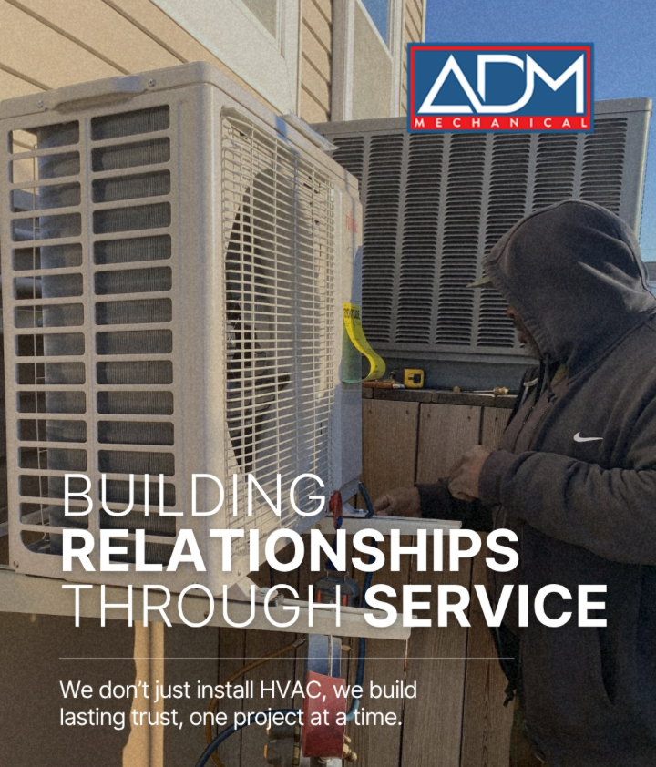 A gray air conditioner is sitting on a concrete platform outside of a house.