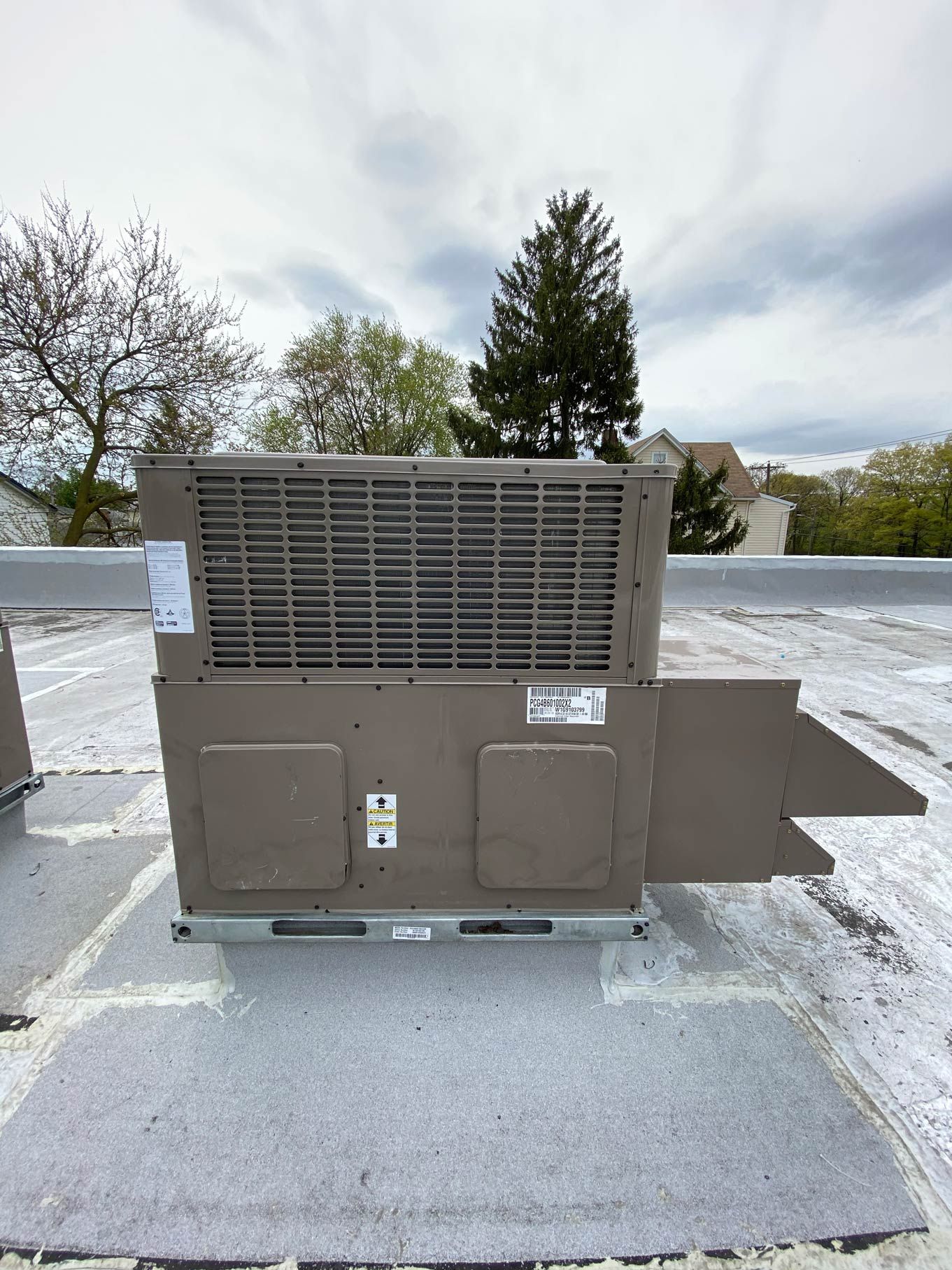 A large air conditioner is sitting on top of a roof.