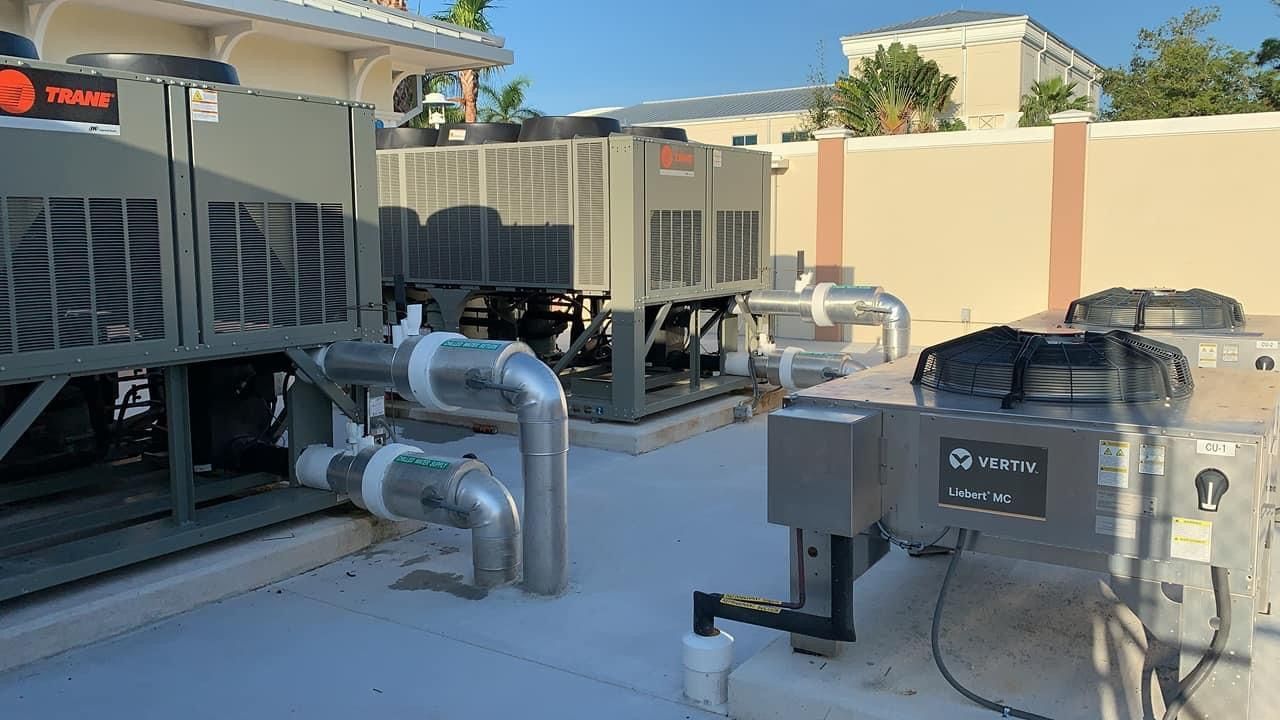 A row of air conditioners are sitting on top of a building.