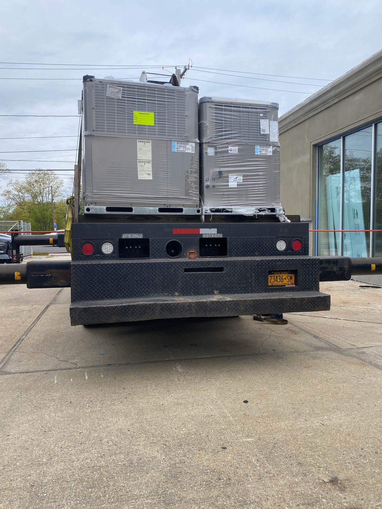 The back of a semi truck is parked in front of a building.