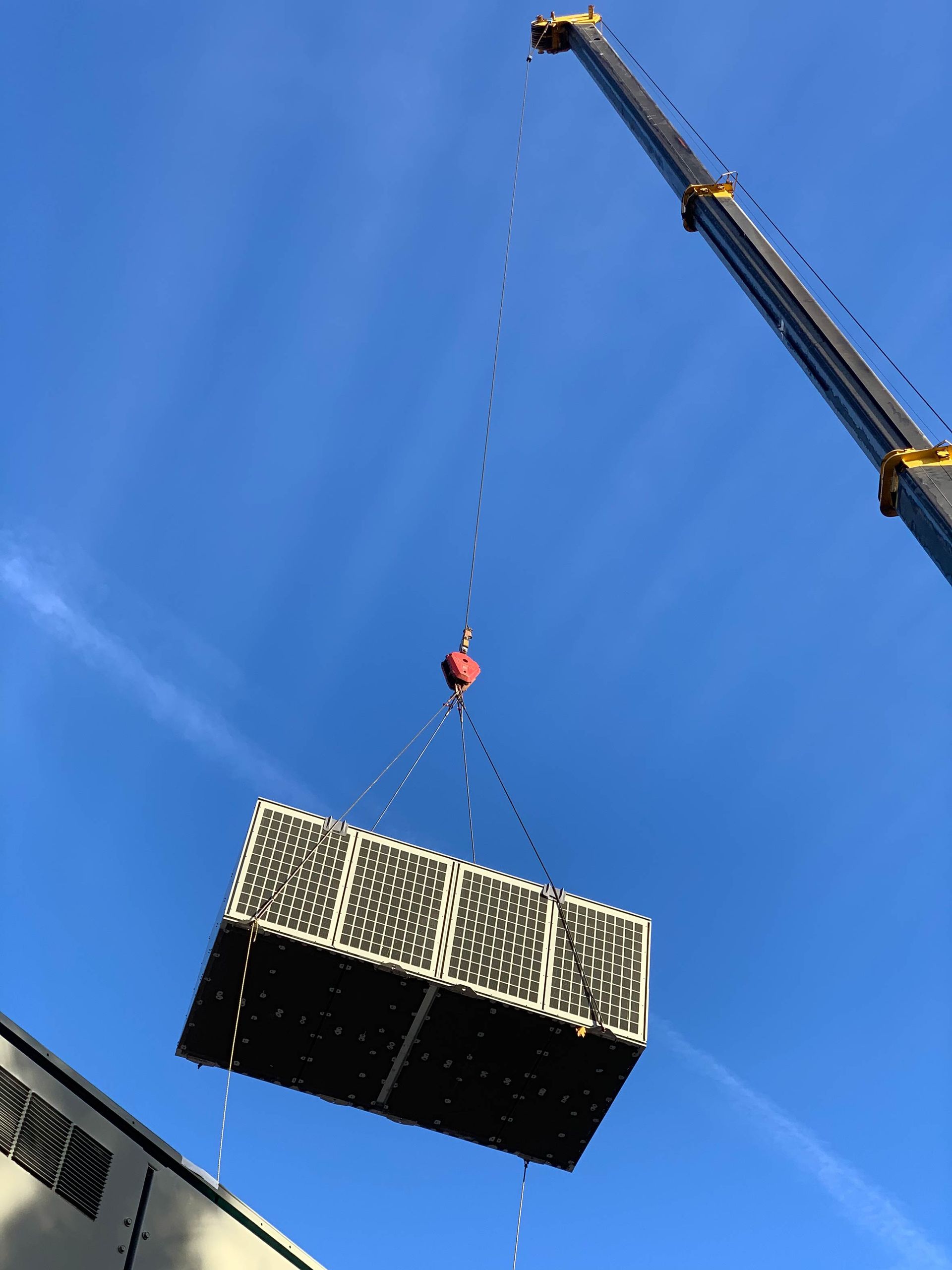 A crane is lifting a large box into the air