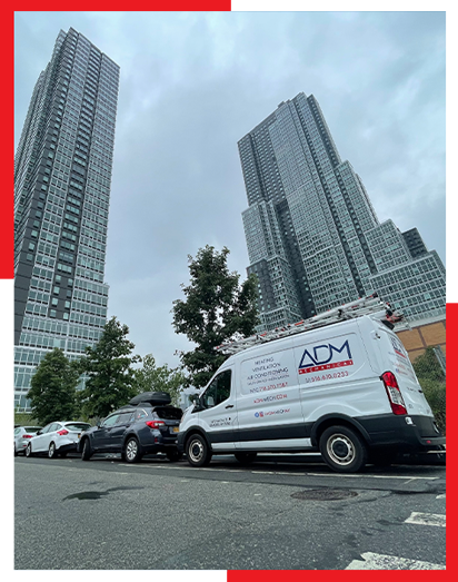 A white adm van is parked in front of a tall building
