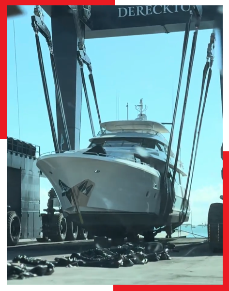 A large white boat is being lifted by a large crane.