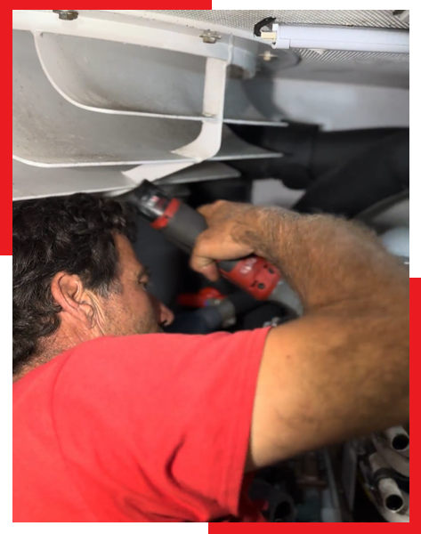 A man in a red shirt is working on a machine