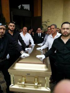Hispanic family saying goodbye to loved one in gold casket at Torres Cremation and Burial Services CA