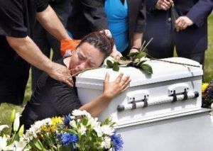 Mother hugging child's casket saying goodbye  at Torres Cremation and Burial Services CA