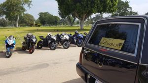 Torres Cremation and Burial Services hearse with motorcycles parked along the side in CA.