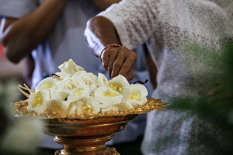 People grabbing wood flowers for hindu cremation